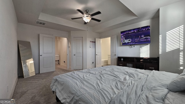 bedroom featuring carpet, ceiling fan, a raised ceiling, and ensuite bath