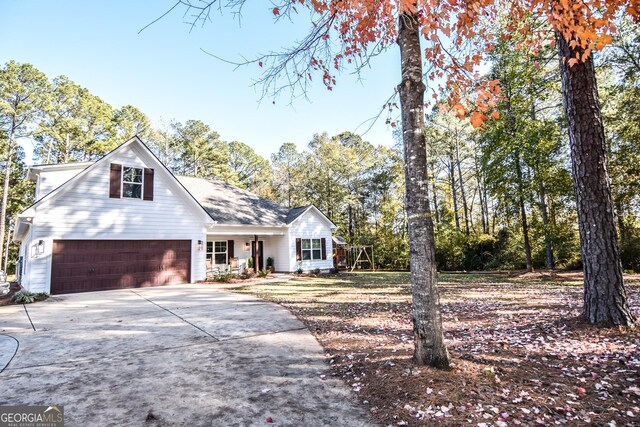 view of front of home with a porch, a garage, and a front yard