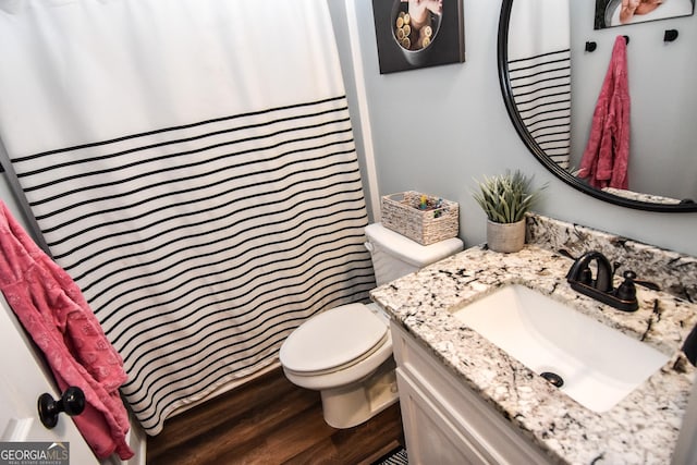 bathroom featuring a shower with shower curtain, vanity, toilet, and wood finished floors