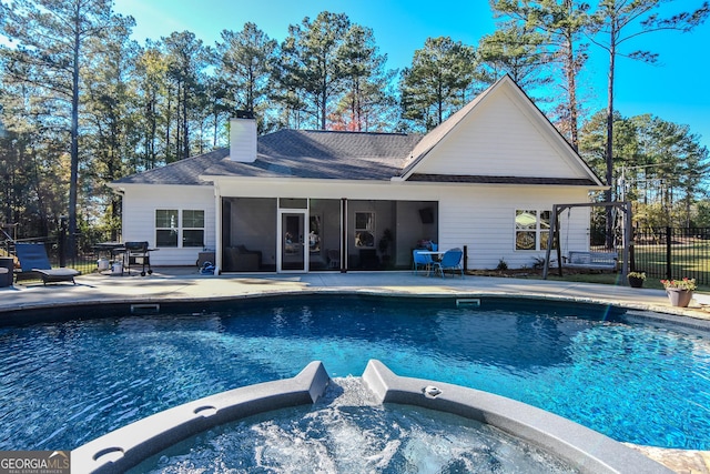 back of property featuring a sunroom, a patio, a hot tub, and fence