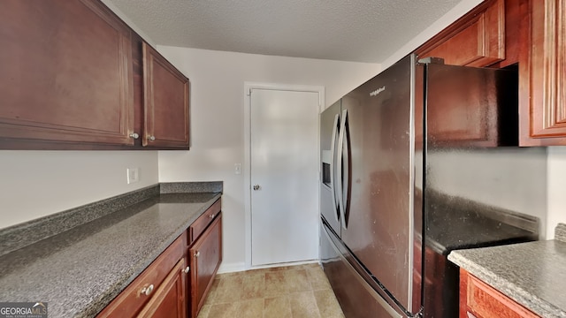 kitchen featuring stainless steel fridge with ice dispenser and a textured ceiling