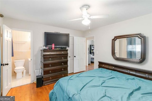 bedroom featuring light wood-type flooring, ceiling fan, and connected bathroom