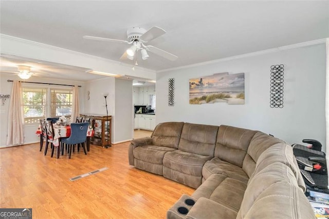 living room featuring hardwood / wood-style floors, ceiling fan, and crown molding