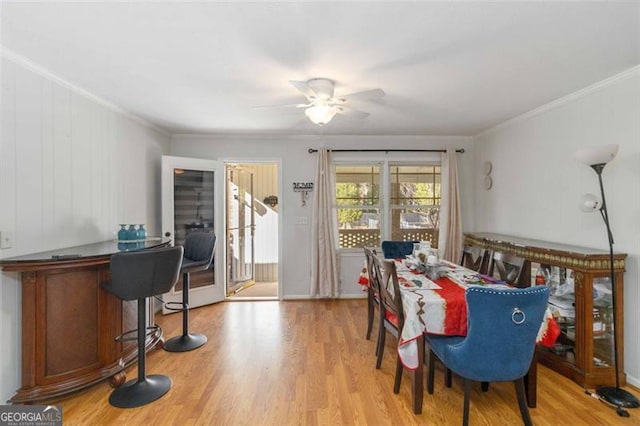 dining area featuring ceiling fan, light hardwood / wood-style floors, and crown molding