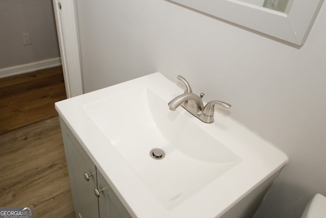 details with wood-type flooring and vanity