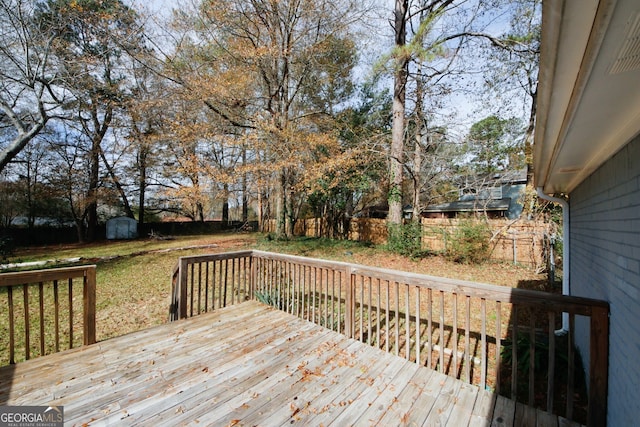 deck with a shed and a yard