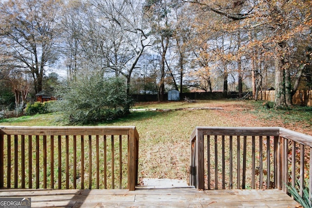 wooden deck featuring a shed and a yard