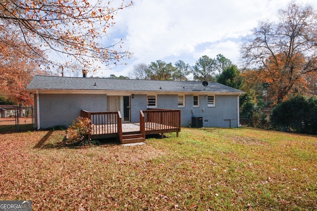 rear view of property featuring central AC, a deck, and a lawn