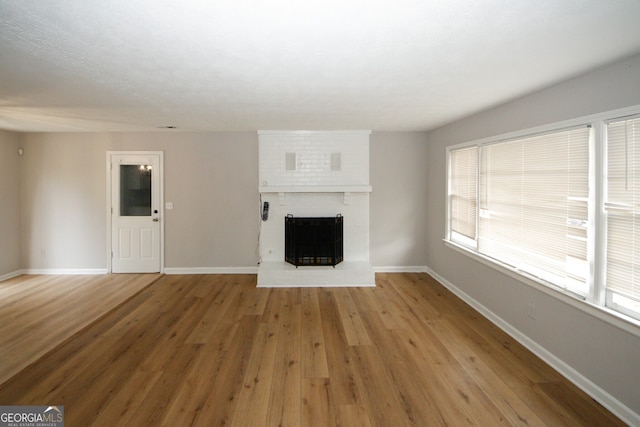 unfurnished living room with a fireplace and wood-type flooring