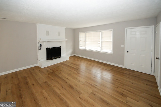 unfurnished living room featuring a fireplace and hardwood / wood-style floors