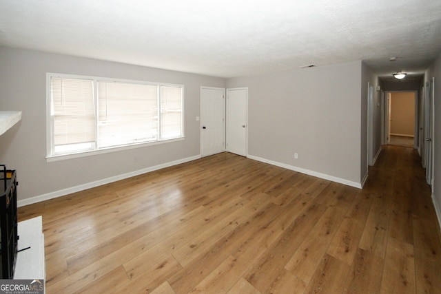 unfurnished living room with wood-type flooring