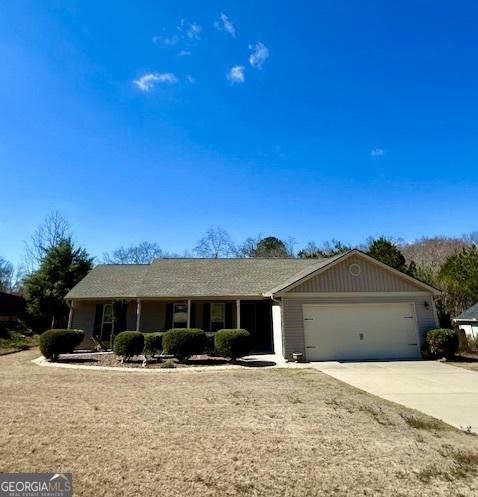 single story home featuring a garage and concrete driveway