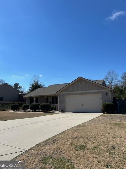 single story home with driveway, an attached garage, and board and batten siding