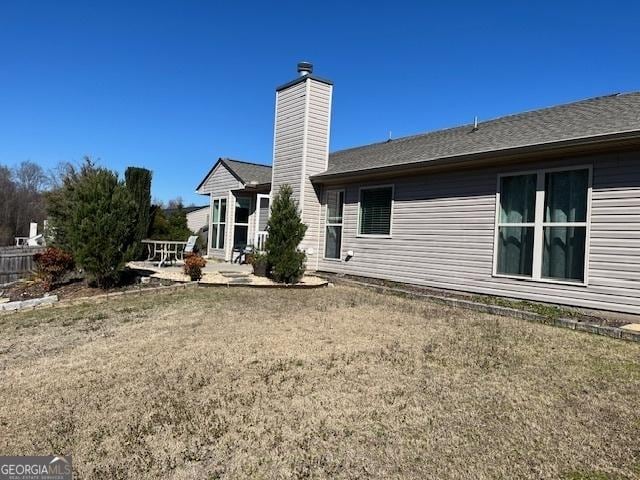 rear view of property with a patio and a chimney