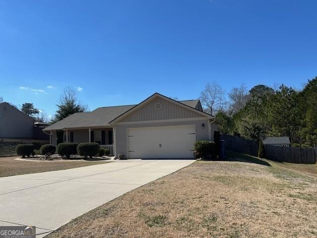 ranch-style home with an attached garage, fence, and concrete driveway