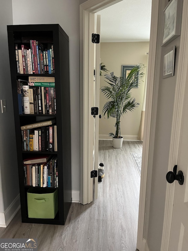 hall with wood finished floors and baseboards