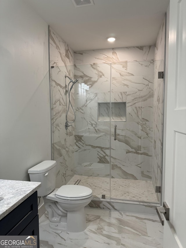 bathroom featuring vanity, toilet, and an enclosed shower