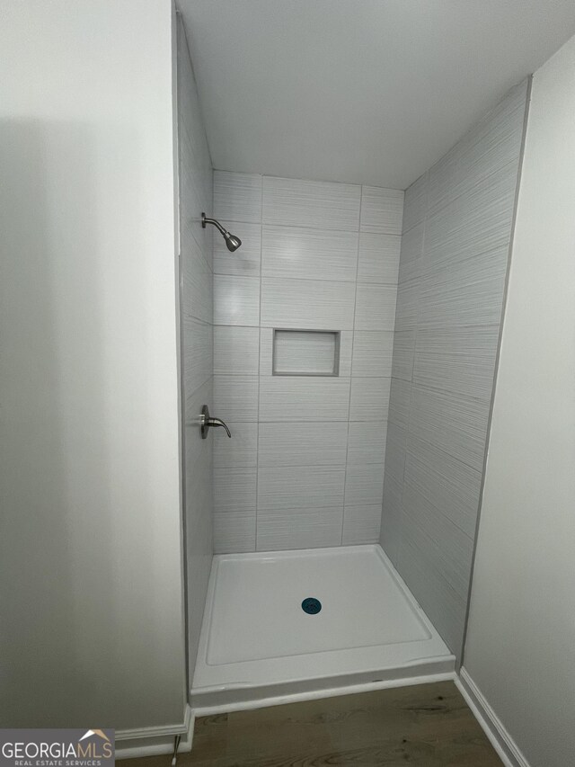 bathroom featuring tiled shower and hardwood / wood-style flooring