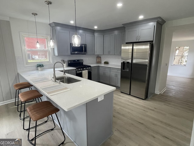 kitchen featuring a healthy amount of sunlight, kitchen peninsula, sink, and appliances with stainless steel finishes