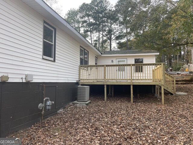 rear view of property with a wooden deck and central AC