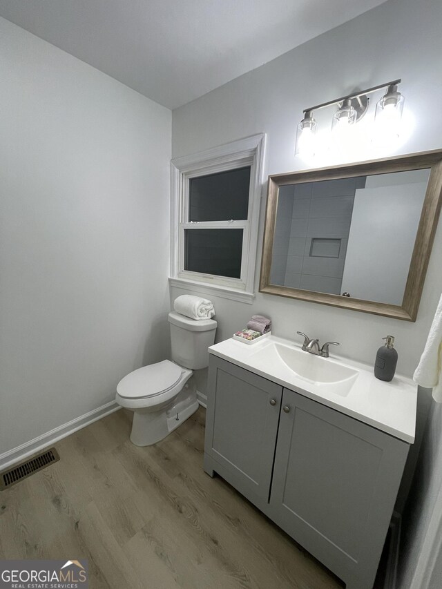 bathroom featuring vanity, hardwood / wood-style flooring, and toilet