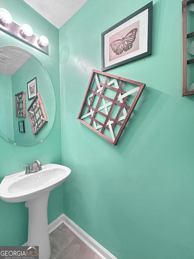 bathroom with tile patterned floors and a textured ceiling