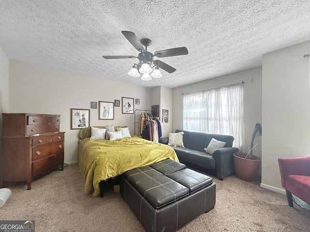 bedroom featuring ceiling fan, a textured ceiling, and light carpet