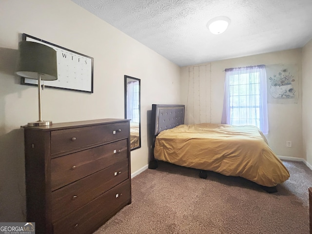 bedroom featuring light carpet and a textured ceiling