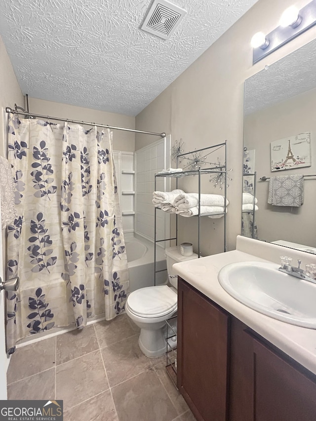 full bathroom with shower / bath combination with curtain, vanity, a textured ceiling, tile patterned flooring, and toilet