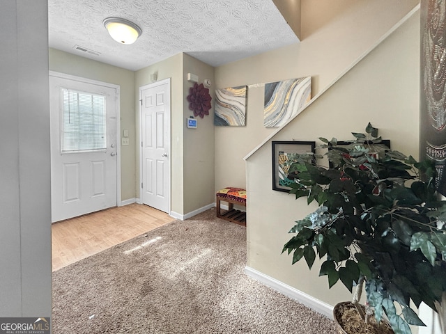 foyer entrance featuring hardwood / wood-style floors and a textured ceiling