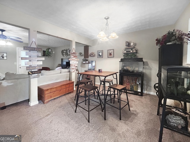 carpeted dining room featuring ceiling fan with notable chandelier and a textured ceiling