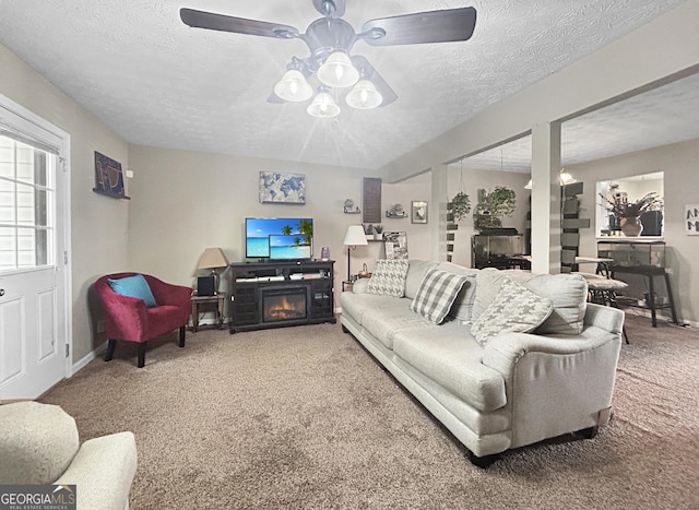 living room with carpet flooring, a textured ceiling, and a fireplace