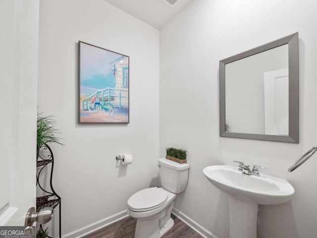 bathroom featuring hardwood / wood-style floors and toilet