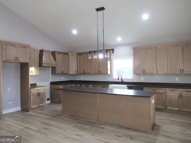 kitchen featuring a center island, sink, light hardwood / wood-style flooring, decorative light fixtures, and custom range hood