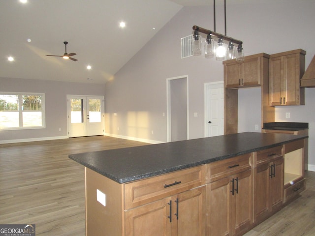 kitchen with ceiling fan, high vaulted ceiling, decorative light fixtures, and light wood-type flooring