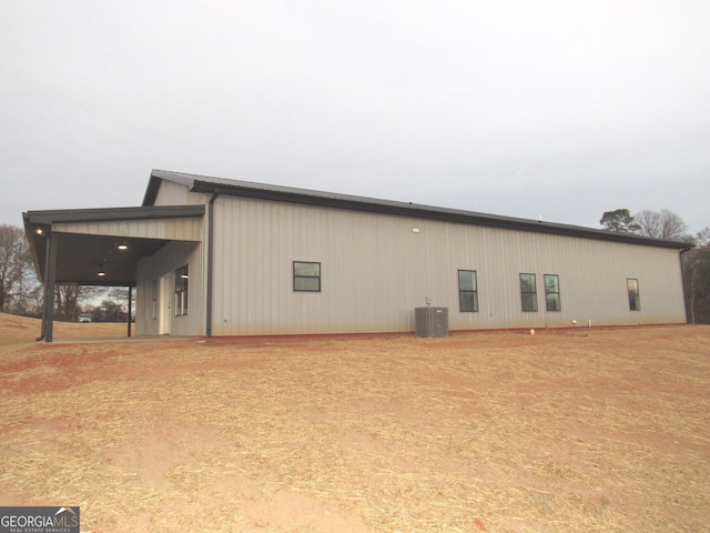 rear view of house featuring central air condition unit and a carport