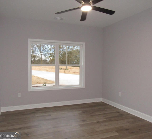 spare room with dark hardwood / wood-style flooring and ceiling fan