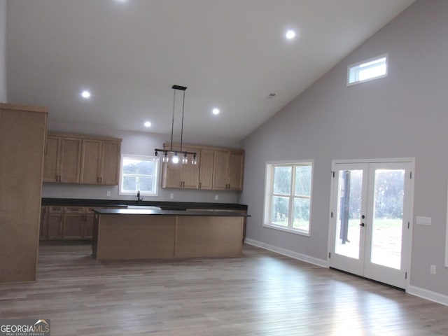 kitchen featuring french doors, decorative light fixtures, high vaulted ceiling, and a healthy amount of sunlight