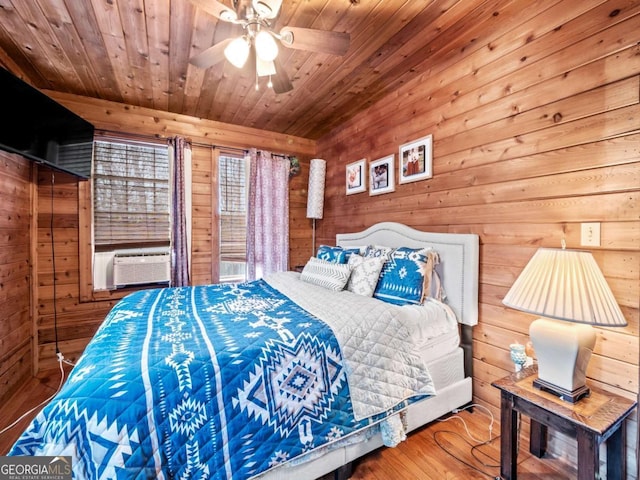 bedroom featuring wood ceiling, ceiling fan, cooling unit, hardwood / wood-style floors, and wooden walls