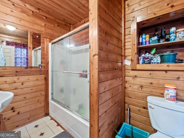 bathroom with wood ceiling, wooden walls, toilet, and combined bath / shower with glass door