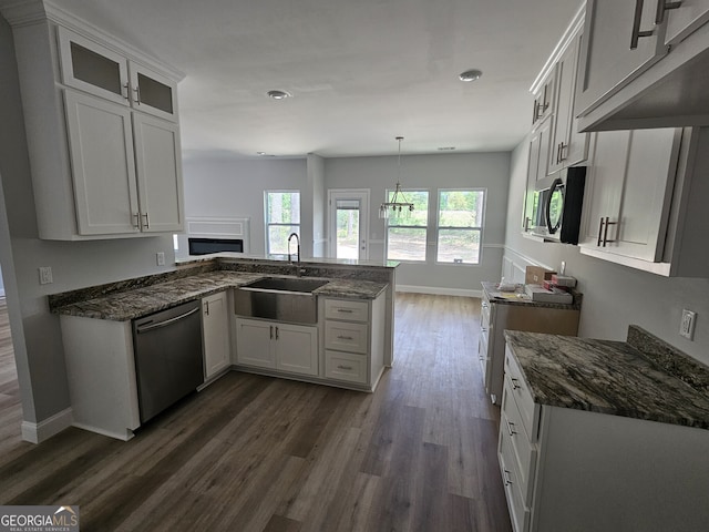 kitchen with kitchen peninsula, white cabinetry, sink, and stainless steel appliances