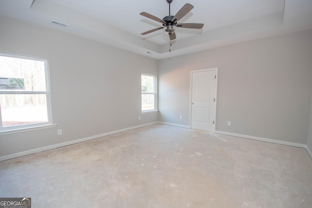 spare room featuring ceiling fan and a tray ceiling