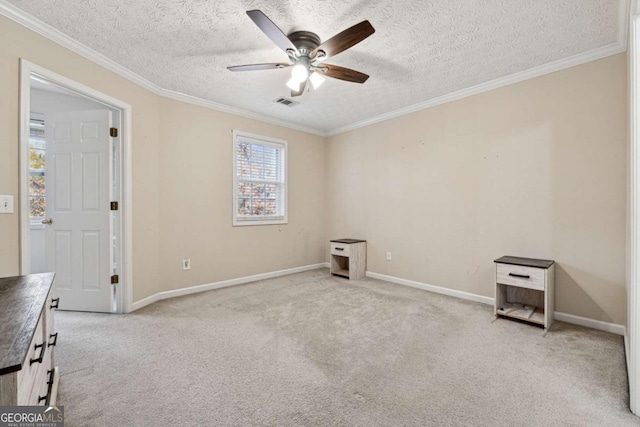 spare room with light carpet, a textured ceiling, ceiling fan, and ornamental molding