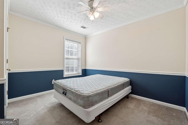 bedroom featuring ceiling fan, light colored carpet, ornamental molding, and a textured ceiling