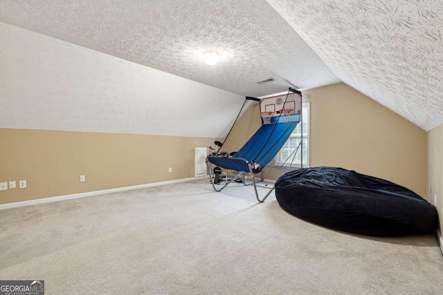 sitting room featuring vaulted ceiling, carpet flooring, and a textured ceiling