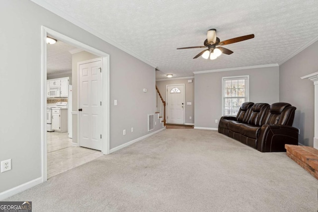 living room featuring a textured ceiling, light colored carpet, ceiling fan, and ornamental molding