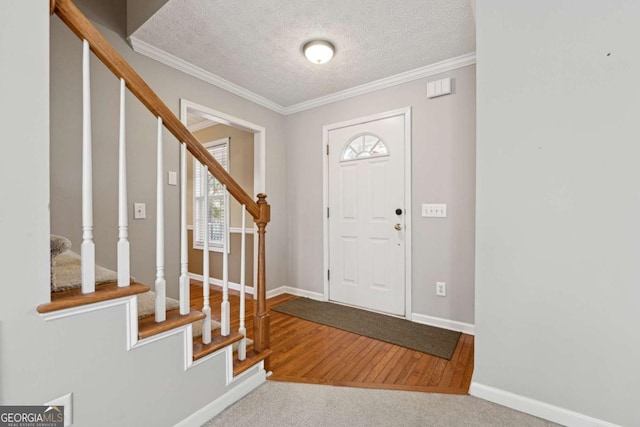 foyer featuring hardwood / wood-style flooring, crown molding, and a textured ceiling