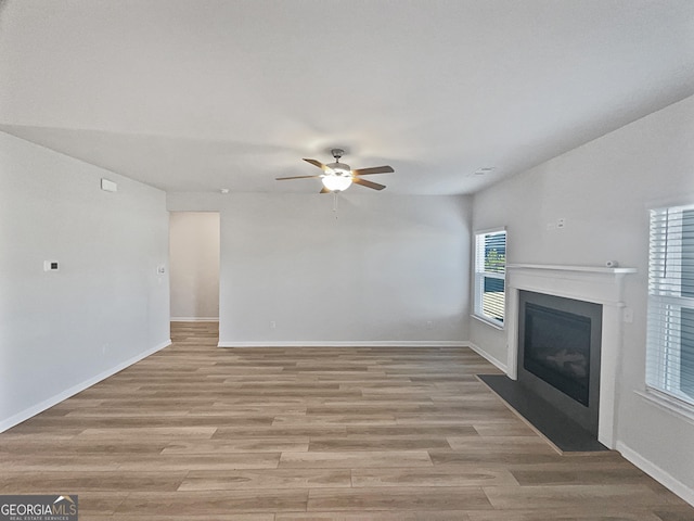 unfurnished living room with ceiling fan and light wood-type flooring