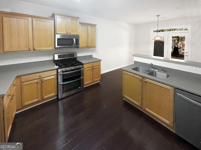 kitchen featuring pendant lighting, dark wood-type flooring, stainless steel appliances, and sink