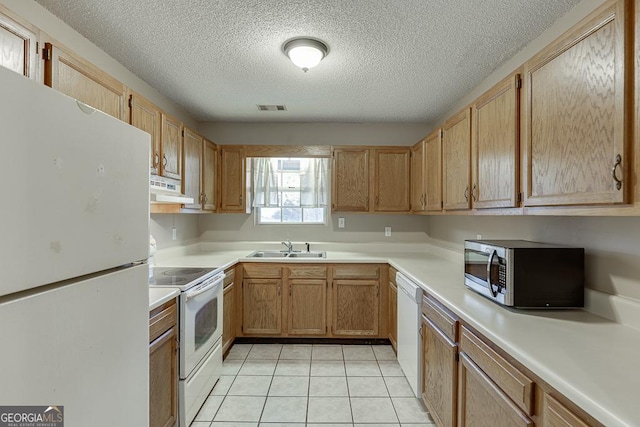 kitchen with a textured ceiling, white appliances, sink, range hood, and light tile patterned flooring